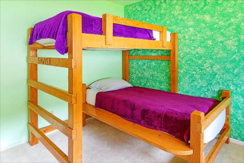 a wooden bunk bed with a purple blanket on it at Linger Longer Lakeside Cottage in Oroville