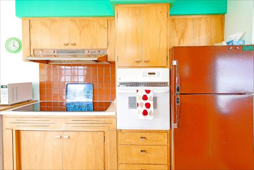 a kitchen with wooden cabinets and a refrigerator at Linger Longer Lakeside Cottage in Oroville