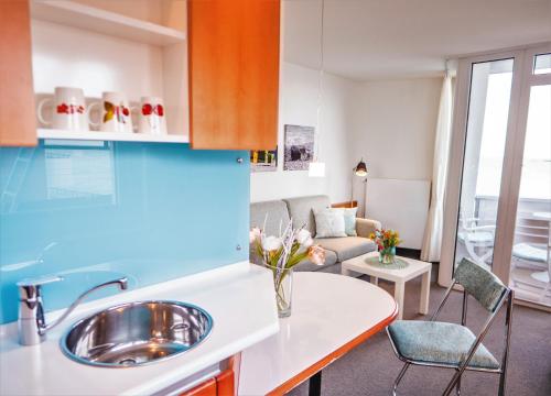 a kitchen with a sink and a living room at Haus Nickels in Helgoland