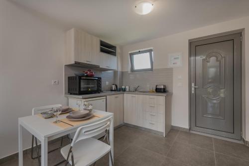 a small kitchen with a table and a microwave at Casa 77 Zante by Karras Hotels in Zakynthos Town