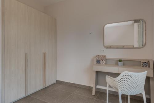 a room with a desk and a mirror and a chair at Casa 77 Zante by Karras Hotels in Zakynthos Town