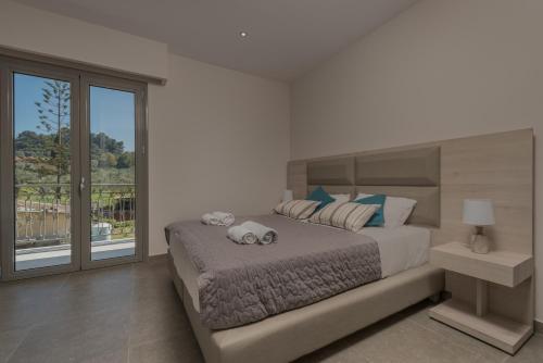 a bedroom with a large bed and a balcony at Casa 77 Zante by Karras Hotels in Zakynthos Town