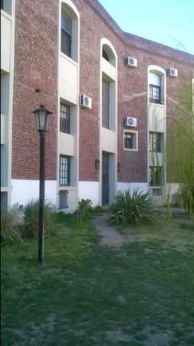 a tall brick building with a street light in the grass at Low cost bahia in Bahía Blanca