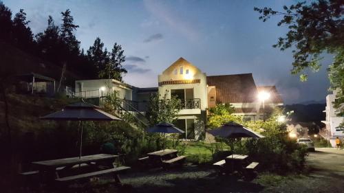 a building with two picnic tables and two umbrellas at Saint Paul De Vence in Damyang