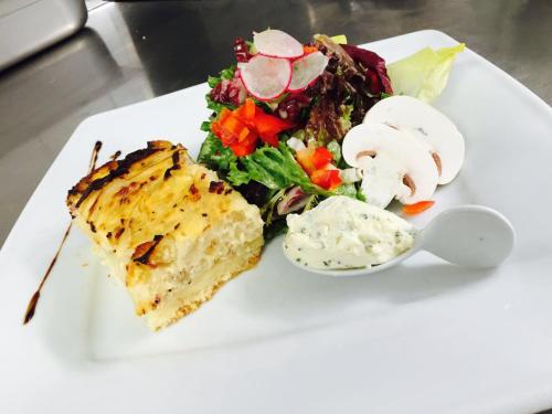 a white plate with a salad and a piece of food at Köln 2020 in Cologne