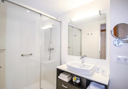 La salle de bains blanche est pourvue d'un lavabo et d'une douche. dans l'établissement Hotel Vista Park, à Can Picafort