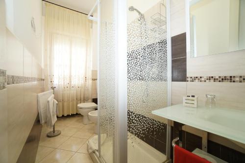 a bathroom with a shower and a toilet and a sink at La Mimosa in Bolgheri