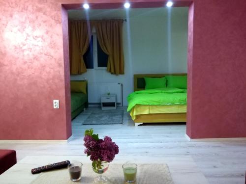 a bedroom with a green bed and a table with flowers at Apartments Vila Selena - Golija in Rudno