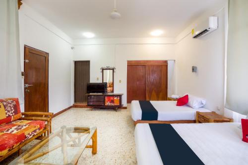 une chambre d'hôtel avec deux lits et un canapé dans l'établissement Hotel Adelita, Zihuatanejo, à Zihuatanejo