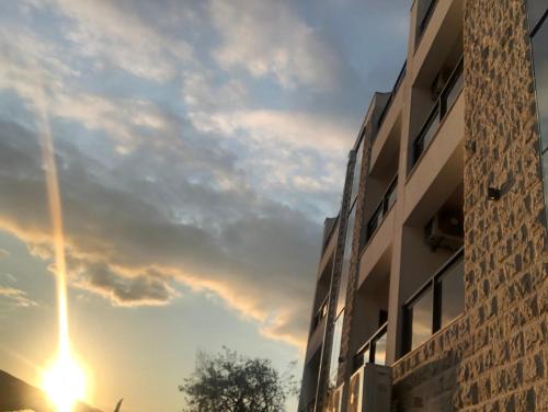 a building with the sunset in the sky at Apartments Bane in Herceg-Novi