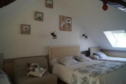 a bedroom with two beds and a chair at Chambres d'Hôtes La Loubatais in Dol-de-Bretagne