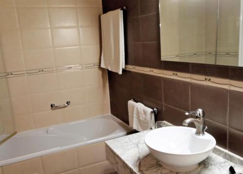 a bathroom with a sink and a bath tub at Hotel Muralleta in Riba-Roja De Turia