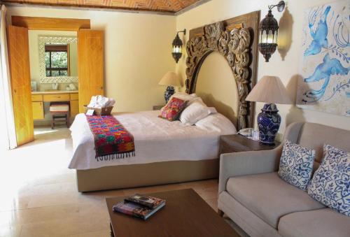a bedroom with a king sized bed and a couch at Hotel Lindo Ajijic Bed & Breakfast in Ajijic