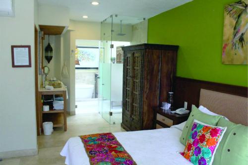 a bedroom with a bed and a green wall at Hotel Lindo Ajijic Bed & Breakfast in Ajijic