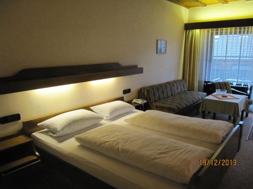 a hotel room with a large bed and a couch at Gasthaus-Krone-Post in Simonswald