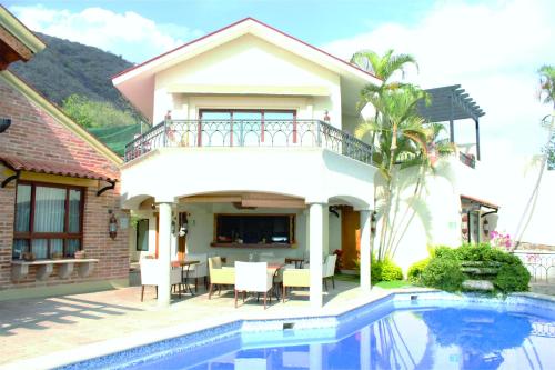 a villa with a swimming pool in front of a house at Hotel Lindo Ajijic Bed & Breakfast in Ajijic