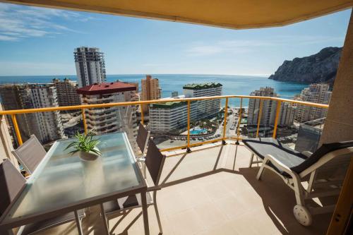 balcón con mesa, sillas y vistas al océano en En la playa. Planta 19. Vistas espectaculares. 2 terrazas., en Calpe