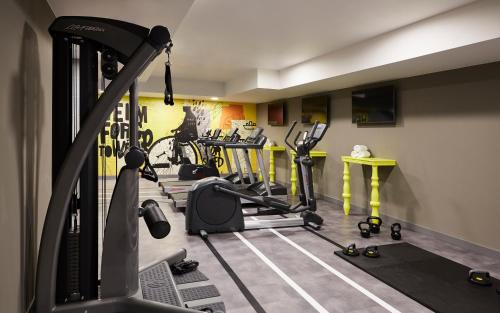 a gym with several tread machines in a room at Hotel Indigo Dresden - Wettiner Platz, an IHG Hotel in Dresden