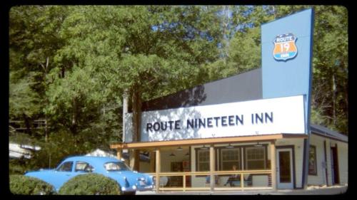 a blue car parked in front of a building at Route 19 Inn in Maggie Valley