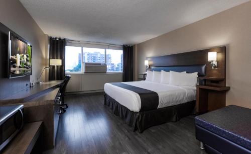 فندق اسبريسو مونتريال سنتر- فيل / داونتاون في مونتريال: غرفة فندقية بسرير ونافذة كبيرة