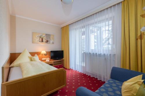 a hotel room with a bed and a window at Aparthotel Grabner in Bad Füssing