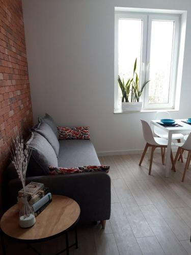 a living room with a couch and a table at Lawendowo- sauna, basen, domki w ogrodzie i apartamenty w kamienicy in Sandomierz