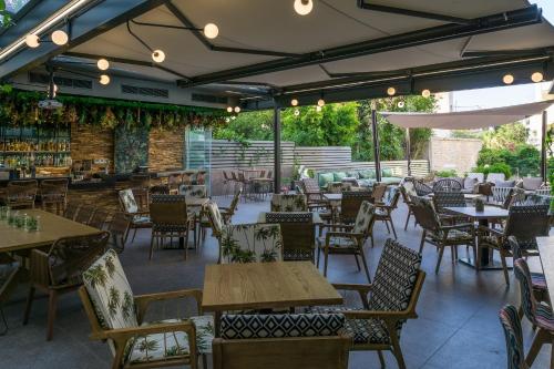 een leeg restaurant met tafels en stoelen en een patio bij Palmyra Beach Hotel in Athene