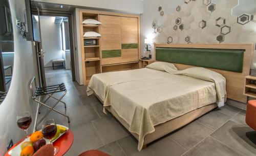 Un dormitorio con una cama y una mesa con un bol de fruta en Palmyra Beach Hotel, en Atenas