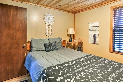 a bedroom with a bed and a wooden door at Rustic Cabin with Hot Tub Near Broken Bow Lake! in Broken Bow