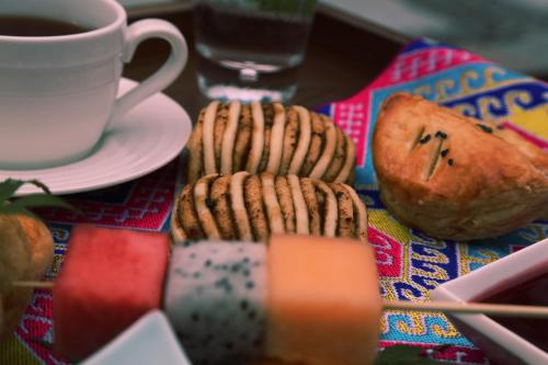 a table with a plate of cookies and a cup of coffee at Howard Johnson Neodalle Resort Zhangjiajie in Zhangjiajie