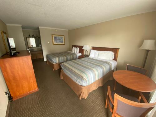 a hotel room with two beds and a table at Snowshoe Motel in Frisco