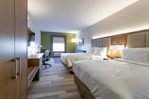 a hotel room with two beds and a desk at Holiday Inn Express & Suites - Columbus - Worthington by IHG in Columbus