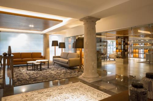 - un hall avec un canapé et une table dans l'établissement Hotel Indigo Guadalajara Expo by IHG, à Guadalajara