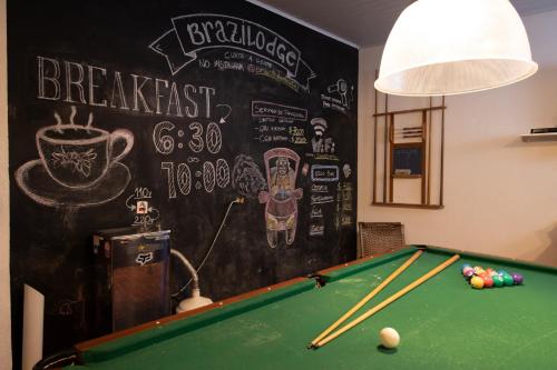 um quarto com uma mesa de bilhar e um quadro negro em Brazilodge All Suites Hostel em São Paulo