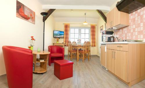 eine Küche und ein Esszimmer mit roten Stühlen und einem Tisch in der Unterkunft Insel-Idyll Sonnenschein in Insel Poel