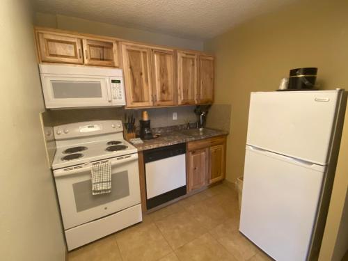 a kitchen with white appliances and wooden cabinets at Snowshoe Motel in Frisco