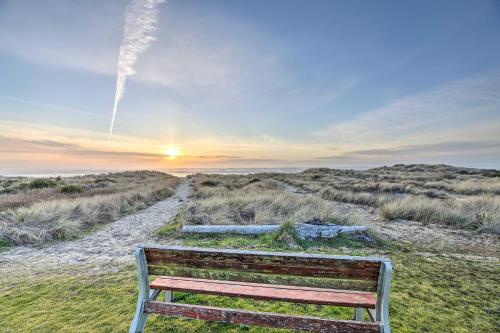 a bench sitting in the grass near a dirt road at Sanderling Sea Cottages, Unit 2 Walk to Coast! in Waldport