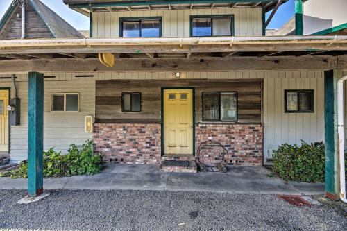 a brick house with a yellow door on a street at Sanderling Sea Cottages, Unit 2 Walk to Coast! in Waldport