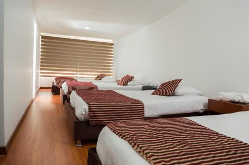 Un grupo de 4 camas en una habitación en Deportel Bogotá, en Bogotá