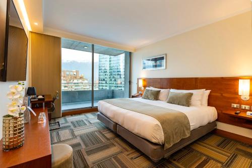 a hotel room with a bed and a large window at Best Western Premier Marina Las Condes in Santiago