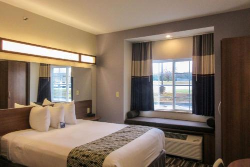 a hotel room with a bed and two windows at Quality Inn & Suites in Caldwell