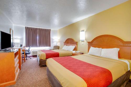 a hotel room with two beds and a flat screen tv at Econo Lodge Inn & Suites Albuquerque East I-40 Eubank Exit in Albuquerque
