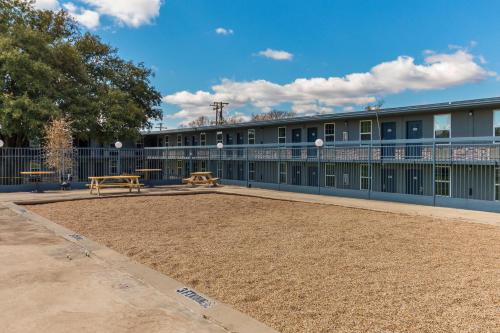 a building with two benches in front of it at Motel 6-Temple, TX in Temple