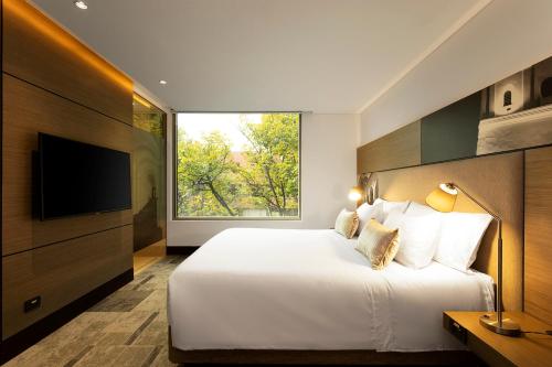 a bedroom with a large bed with a large window at EK Hotel By Preferred Hotels Group in Bogotá