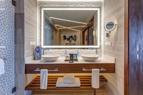 a bathroom with a sink, toilet and mirror at Royalton CHIC Cancun, An Autograph Collection All-Inclusive Resort - Adults Only in Cancún