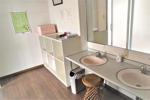 a bathroom with two sinks and a large mirror at Sakurakan in Minami Kyushu