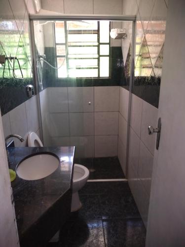 a bathroom with a toilet and a sink and a shower at Pousada Santa Felicidade, garagem T in Curitiba
