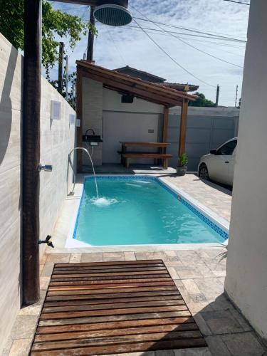 een zwembad met een fontein in een tuin bij Casa com piscina em c vermelha in Porto Seguro