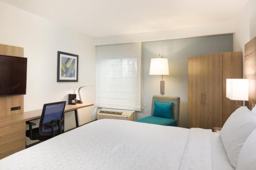 a hotel room with a bed and a desk and chair at Holiday Inn Express San Jose Costa Rica Airport by IHG in Alajuela City
