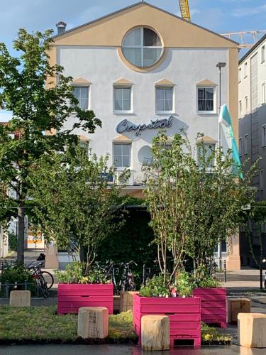 a building with pink benches in front of it at Hotel Capitol Zentrum - 24h - in Friedrichshafen